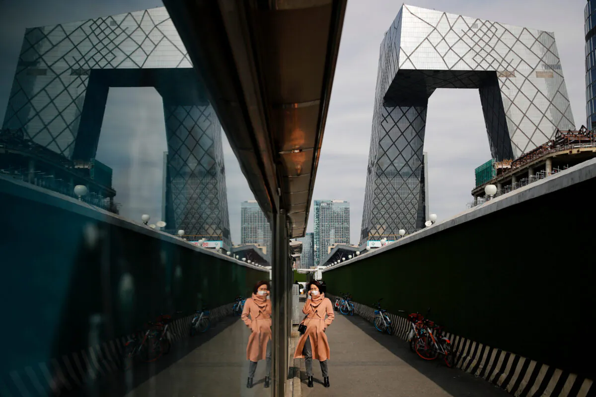 A woman wearing a protective face mask talks on her phone at the Central Business District in Beijing, on March 2, 2020.  (AP Photo/Andy Wong)