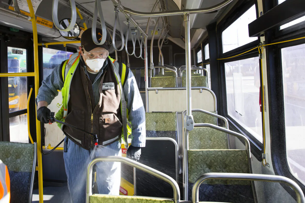 A King County Metro worker sprays a disinfectant on a metro bus in Seattle, Washington, on March 4, 2020. (Karen Ducey/Getty Images)