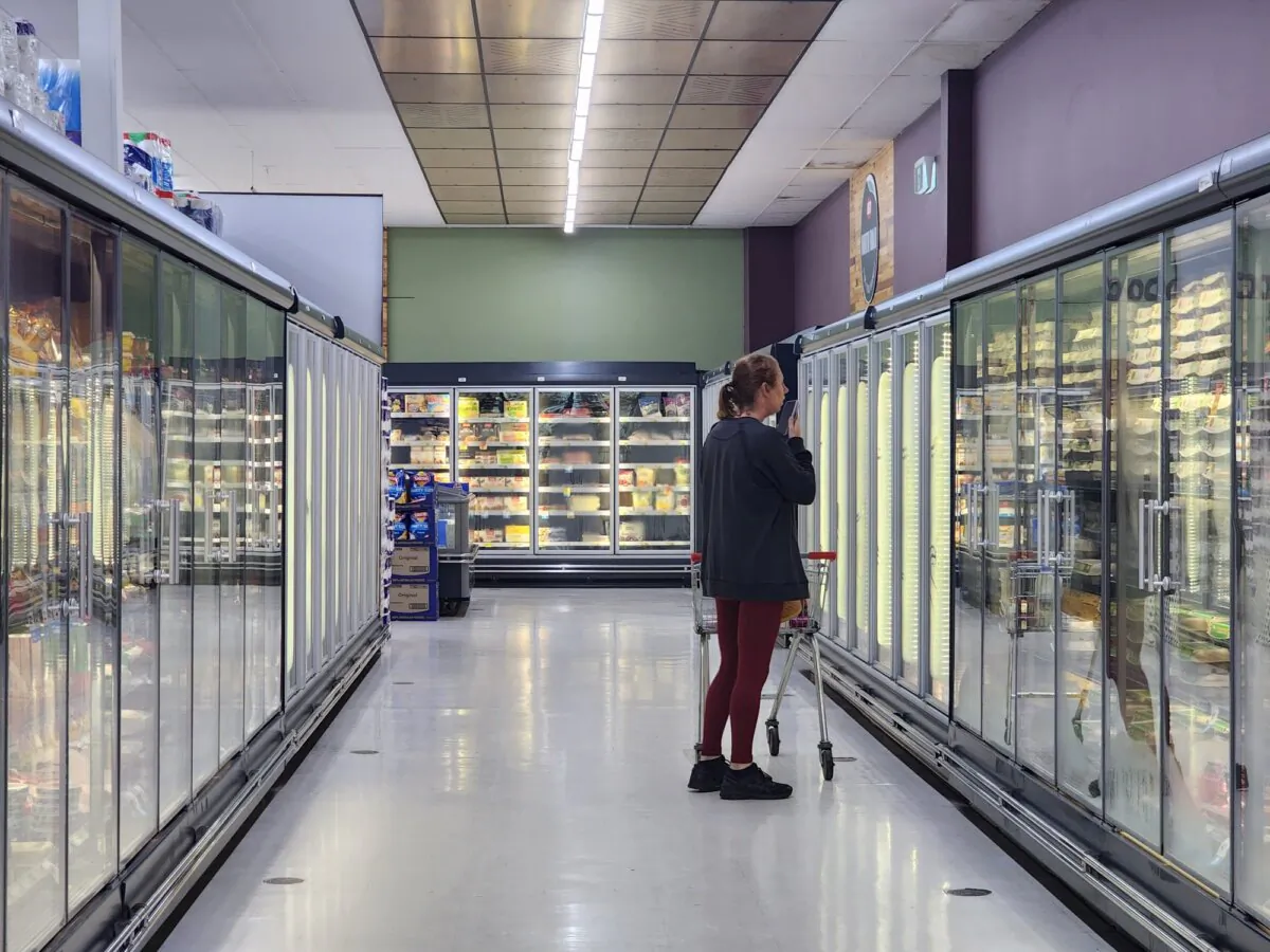 A woman shops in the refrigerated section of a supermarket in Western Australia on May 4, 2024. (Susan Mortimer/The Epoch Times)
