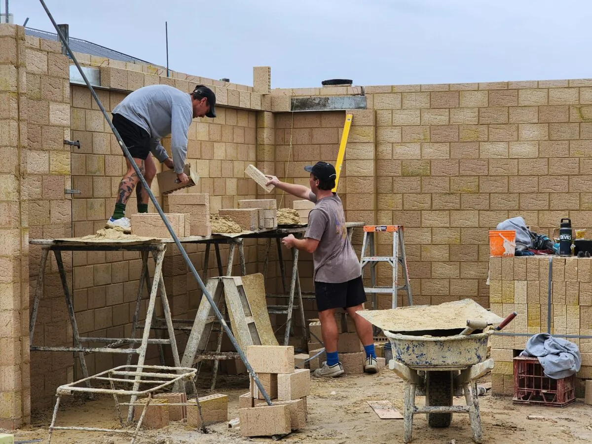 Two bricklayers work on a new home in Albany, Western Australia, on July 5, 2024. (Susan Mortimer/The Epoch Times)