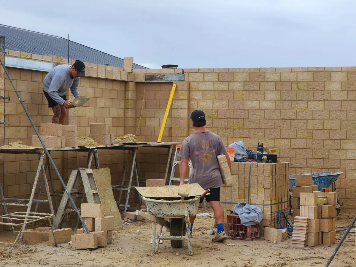 Two bricklayers work on a new home in Albany, Western Australia, on July 5, 2024. (Susan Mortimer/The Epoch Times)