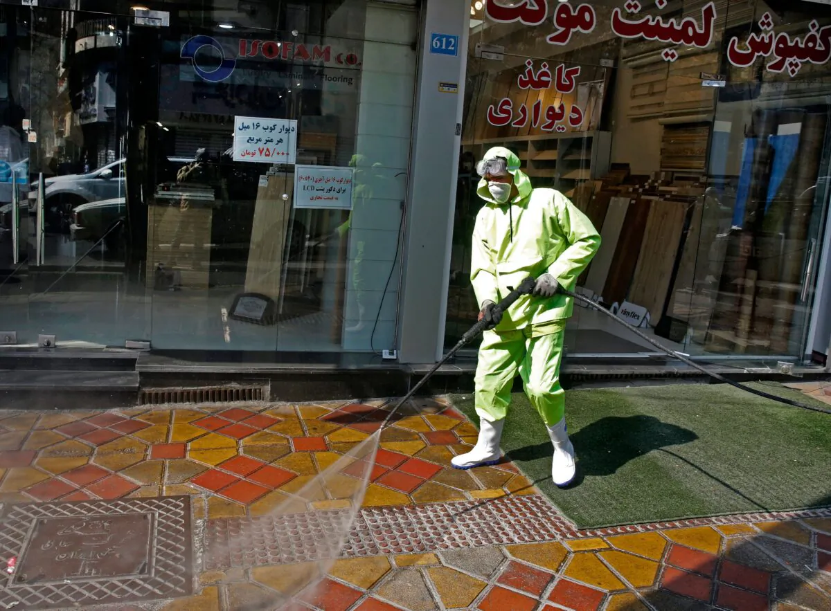 Iranian fire fighters and municipality workers disinfect a street in the capital Tehran for corona virus COVID-19 on March 5, 2020. (Stringer/AFP via Getty Images)