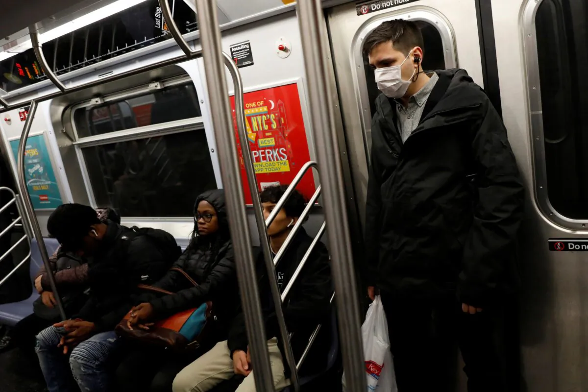 A man in a face mask rides the subway in Manhattan, New York City, after further cases of coronavirus were confirmed in New York on March 5, 2020. (Andrew Kelly/Reuters)