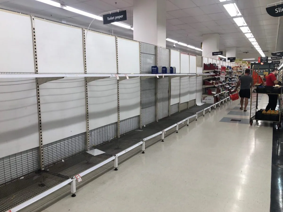 Shoppers walk past a near-empty section of toilet paper at a Coles supermarket in Sydney on March 3, 2020. (Mimi Nguyen Ly/The Epoch Times)
