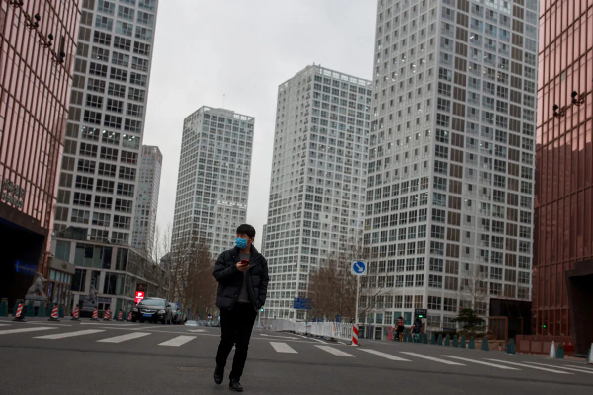 A man wears a mask as he crosses a street in a business district in Beijing, China as the country is hit by the novel coronavirus outbreak, on March 2, 2020. (Thomas Peter/Reuters)
