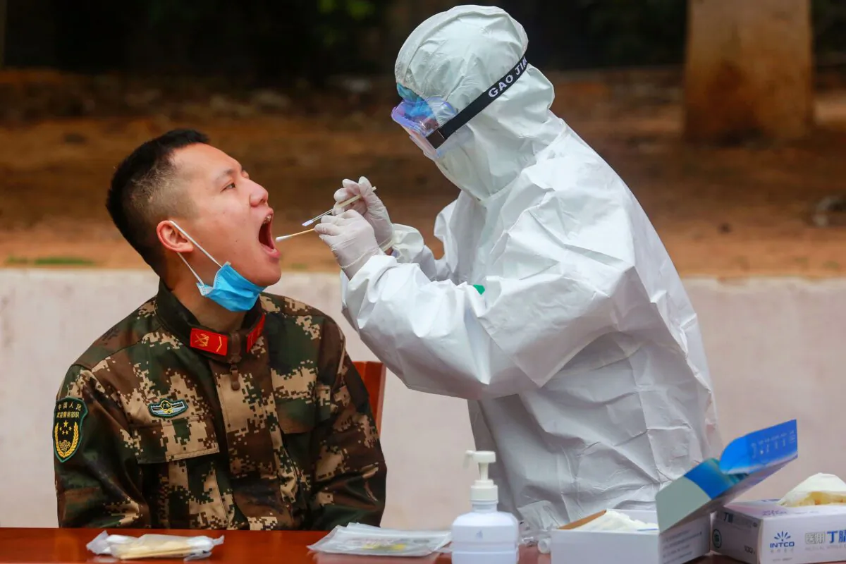 A medical staff member collects samples from Chinese paramilitary police officers to be tested for COVID-19, in Shenzhen, China, on Feb. 11, 2020. (STR/AFP via Getty Images)