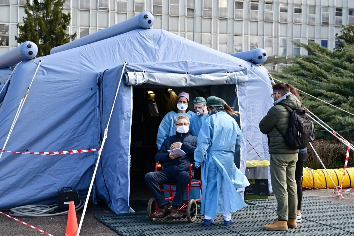 A man receives assistance in the a pre-triage medical tent in front of the Cremona hospital, in Cremona, northern Italy, on March 4, 2020. (Miguel Medina/AFP via Getty Images)