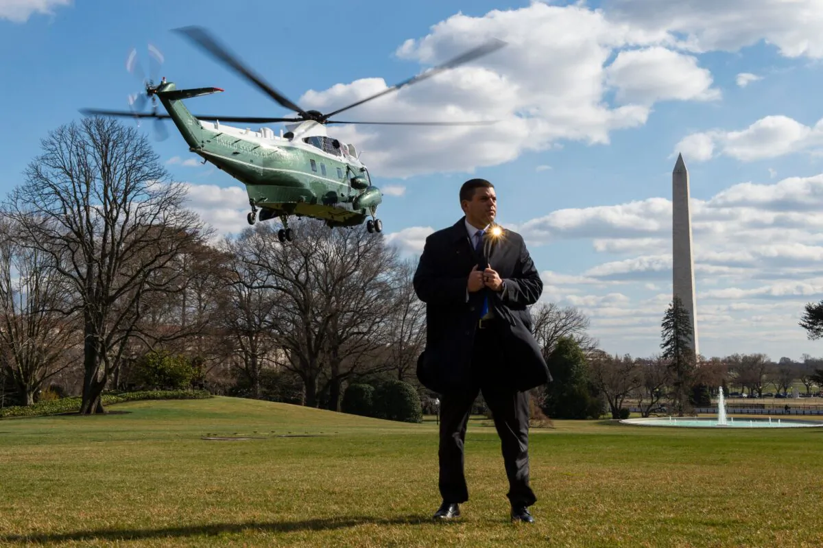 A Secret Service agent stands on the South Lawn of the White House as Marine One helicopter lifts off with US President Donald Trump on board in Washington on Feb. 29, 2020. (Roberto Schmidt/AFP via Getty Images)