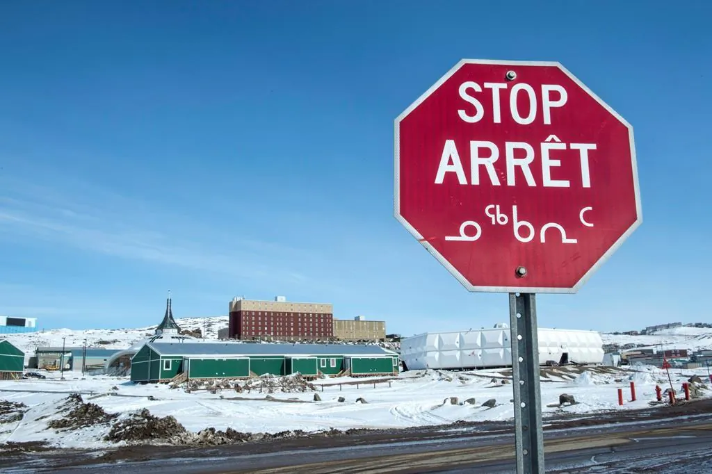 A stop sign in English, French and Inuit is seen in Iqaluit, Nunavut on April 25, 2015. (Paul Chiasson/The Canadian Press)