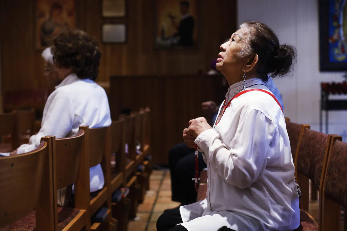 Esther Gianan, a retired registered nurse, prays for those who are affected by the coronavirus during Mass at St. Lawrence Catholic Church in Tampa, Fla., on March 6, 2020. (Octavio Jones/Tampa Bay Times via AP)