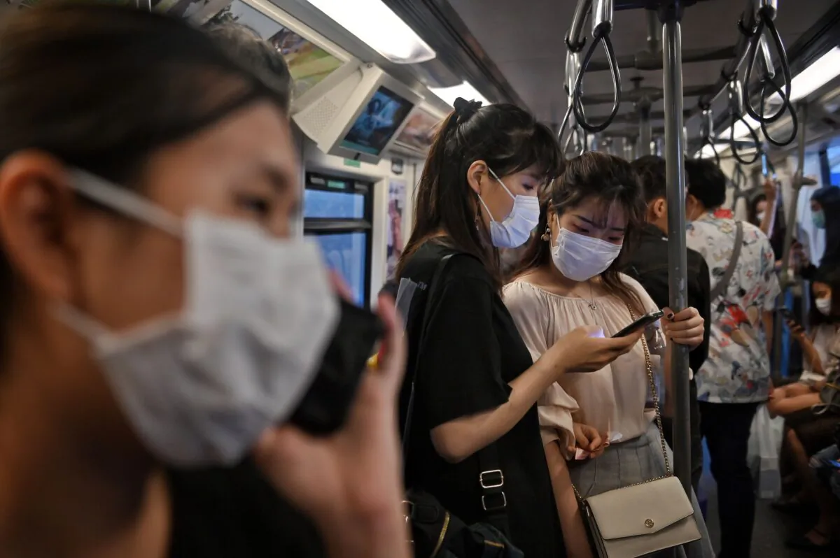People wearing face masks ride the BTS Skytrain station in Bangkok on March 6, 2020. (Lillian Suwanrumpha/AFP via Getty Images)