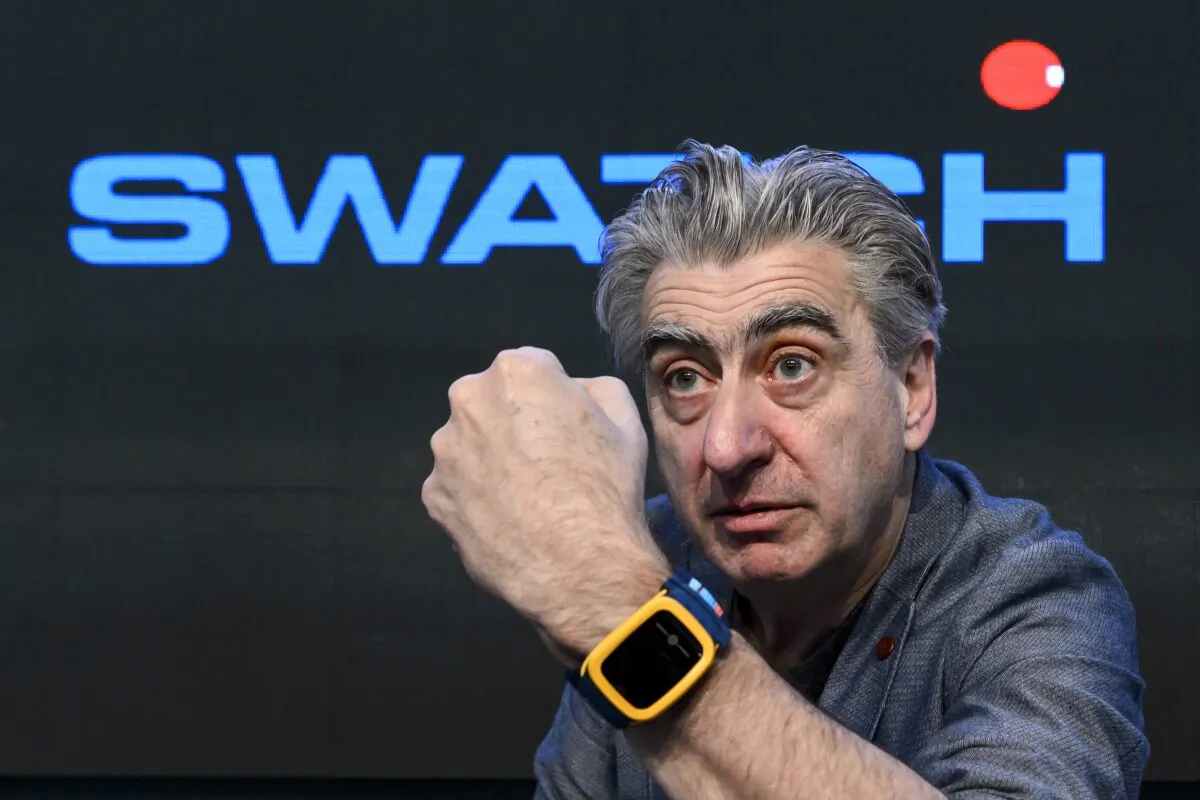Swiss watchmaker Swatch Group CEO Nick Hayek shows the Swatch Touch Zero One wristwatch during a press conference in Corgemont, Switzerland, on March 12, 2014.  (Fabrice Coffrini/AFP via Getty Images)