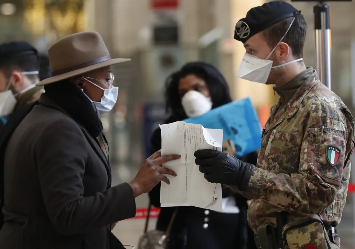 Police officers and soldiers check passengers leaving from Milan main train station, Italy, on March 9, 2020. (Antonio Calanni/AP Photo)