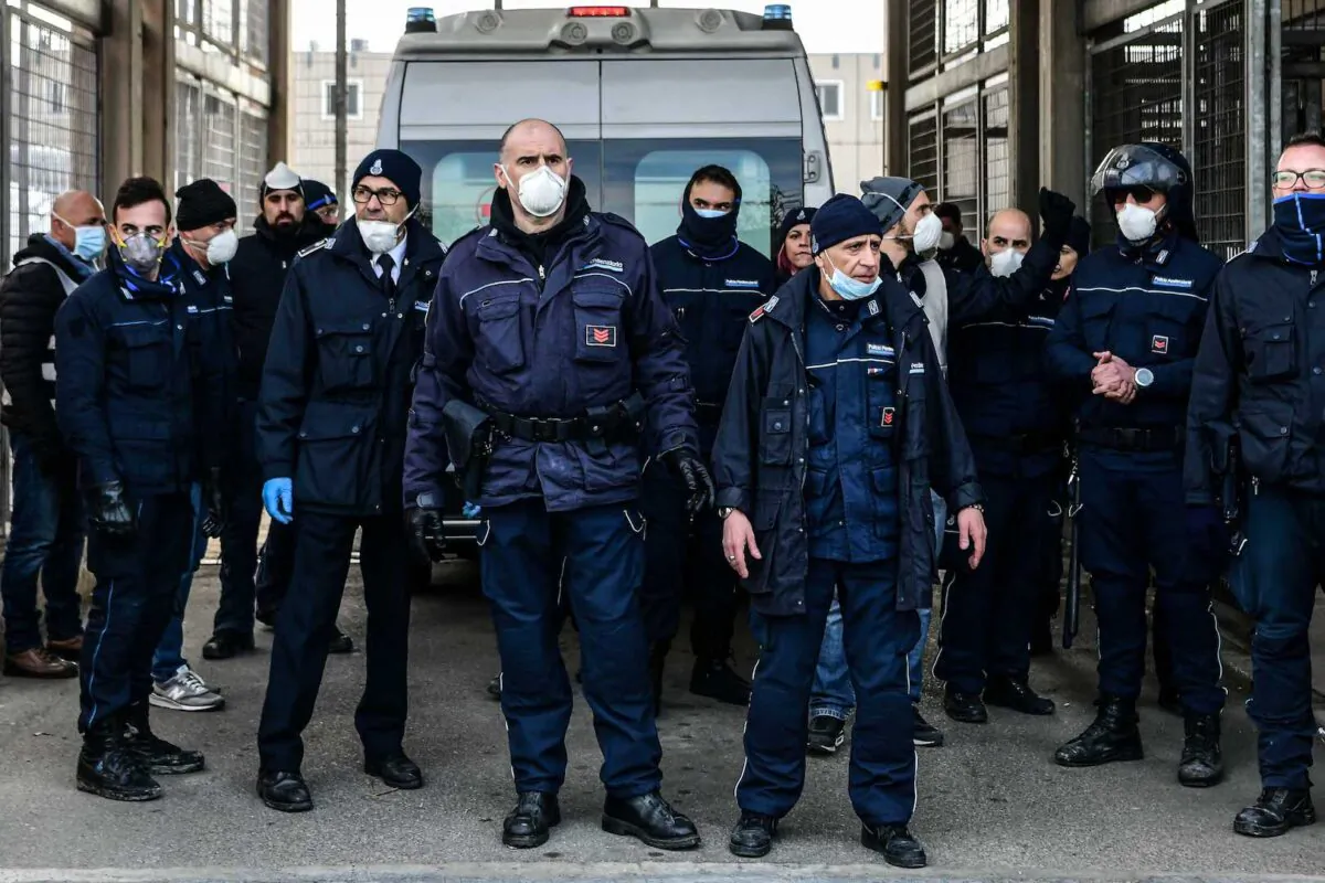 Prison Police officers stand guard after an ambulance (Rear) entered the SantAnna prison during a protest of inmates' relatives in Modena, Emilia-Romagna, in one of Italy's quarantine red zones on March 9, 2020. (Piero Cruciatti/AFP via Getty Images)