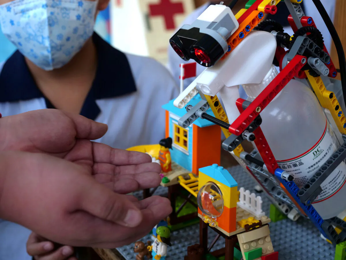 An elementary school student uses a self-built motion sensor controlled disinfectant dispenser assembled with Lego parts, following a novel coronavirus outbreak, in the southern Taiwanese city of Kaohsiung, Taiwan on March 9, 2020. (Fabian Hamacher/Reuters)