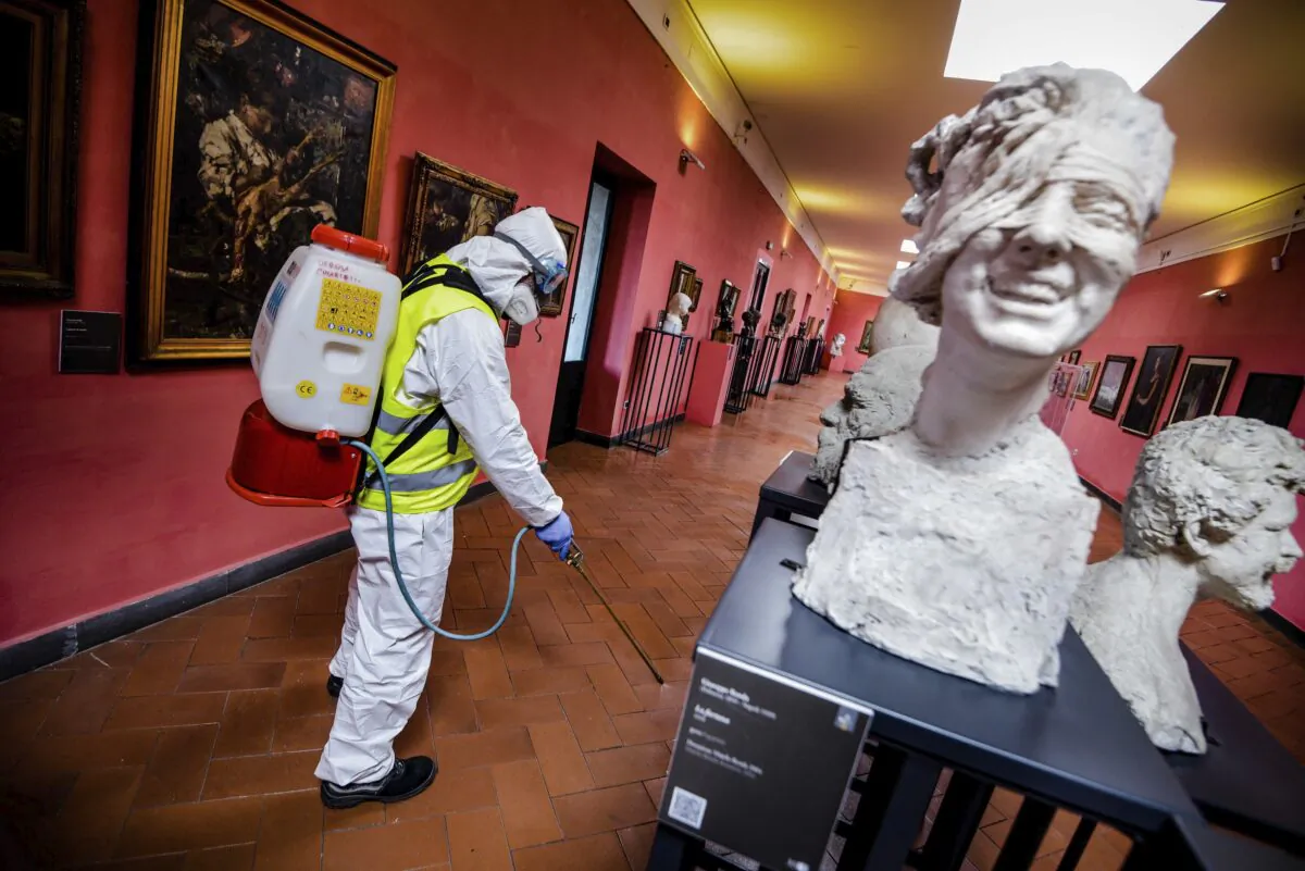 A worker sprays disinfectant as sanitization operations against Coronavirus are carried out in the museum hosted by the Maschio Angioino medieval castle, in Naples, Italy, on March 10, 2020. (Alessandro Pone/LaPresse via AP)