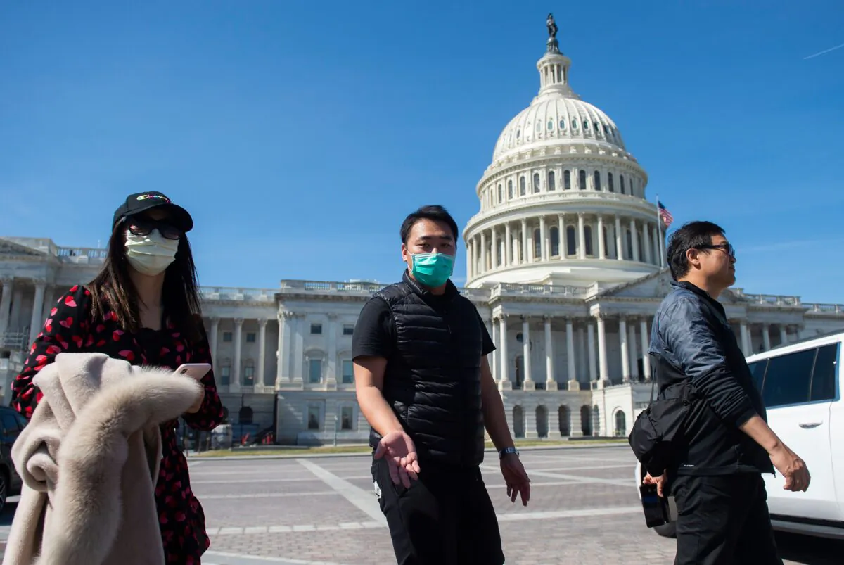 A tour operator, wearing a protective mask, gestures as he leads a tour near the US Capitol in Washington on March 9, 2020. (Andrew Caballero-Reynolds/AFP via Getty Images)