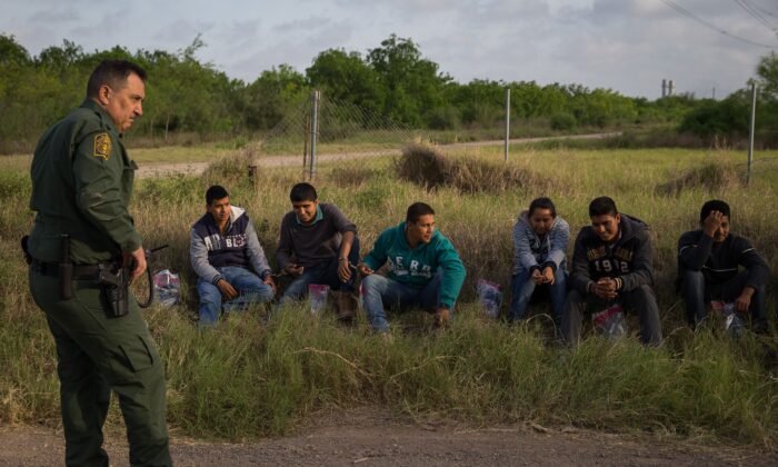 A Border Patrol agent apprehends illegal immigrants shortly after they crossed the border from Mexico into the United States in the Rio Grande Valley Sector near McAllen, Texas, on March 26, 2018.
(Loren Elliott/AFP via Getty Images)