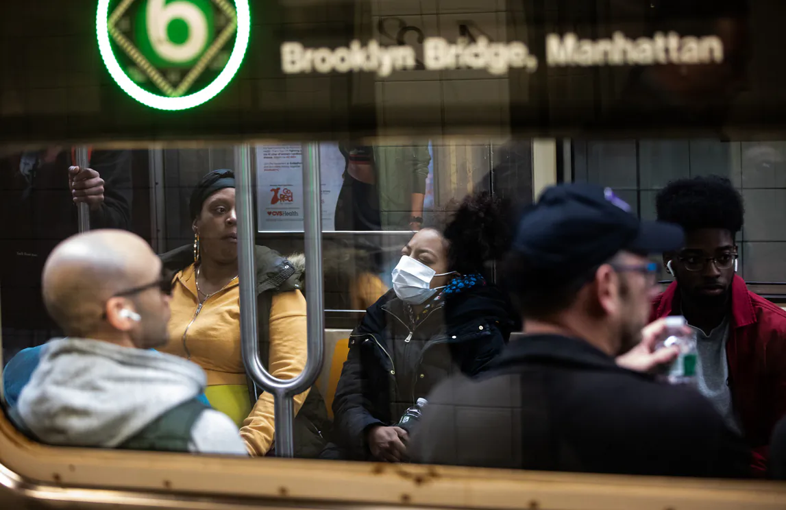 A woman wearing a protective mask rides a subway in New York City on March 9, 2020. (Jeenah Moon/Getty Images)