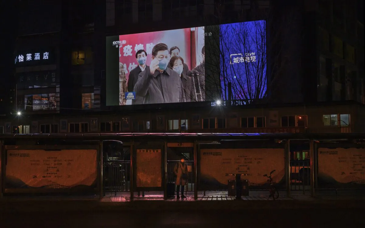 A large screen in the street shows Chinese leader Xi Jinping wearing a protective mask during his visit to Wuhan, the epicentre of the coronavirus, on CCTV's evening newscast in Beijing on March 10, 2020. (Kevin Frayer/Getty Images)