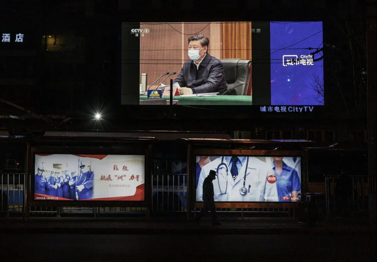 A large screen shows Chinese leader Xi Jinping wearing a protective mask during his visit to Wuhan, on CCTV's evening newscast, on March 10, 2020. (Kevin Frayer/Getty Images)