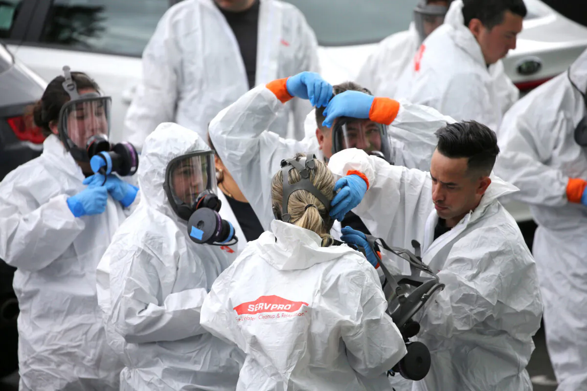 Clean-up crews from Servpro gear up and go inside the Life Care Center of Kirkland, the long-term care facility linked to several confirmed coronavirus cases in the state, in Kirkland, Washington, on March 11, 2020. (Karen Ducey/Reuters)