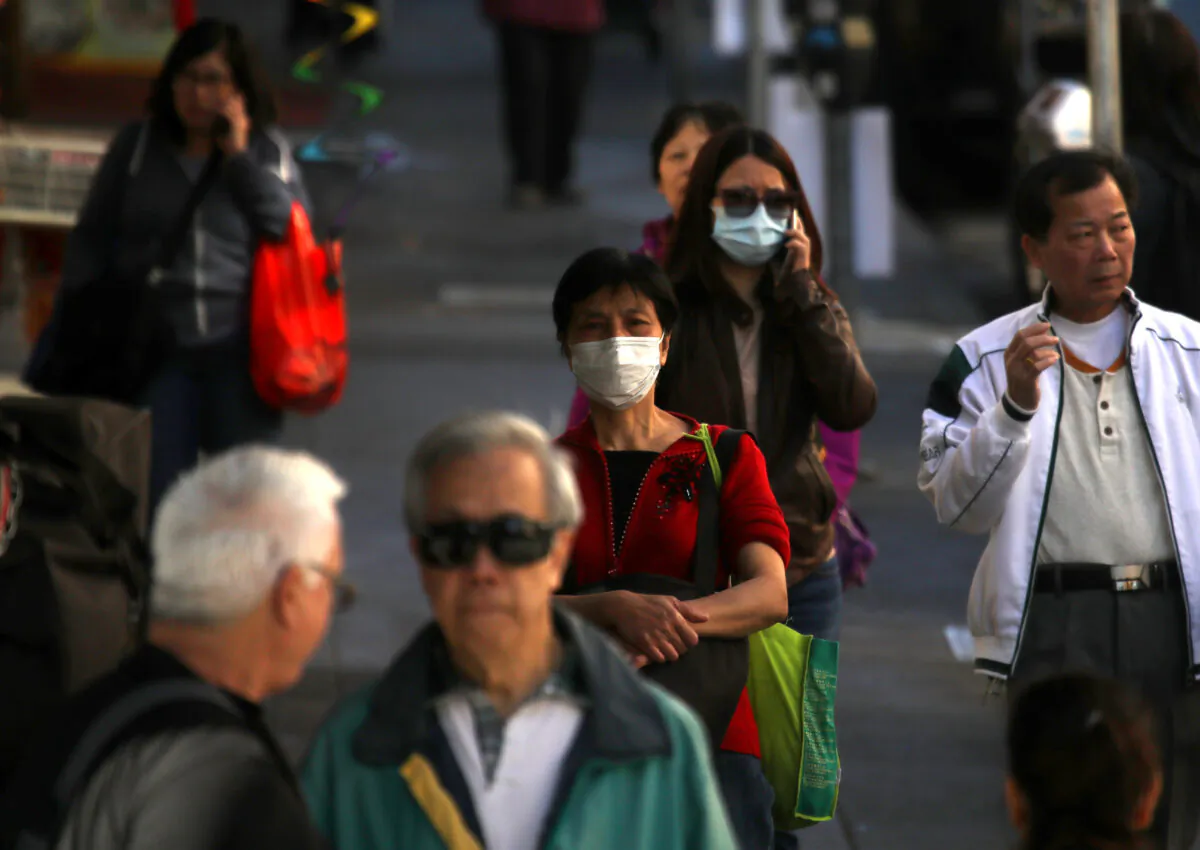 People wear surgical masks as they walk along Chinatown's Grant Avenue in San Francisco, California, on Feb. 26, 2020. (Justin Sullivan/Getty Images)