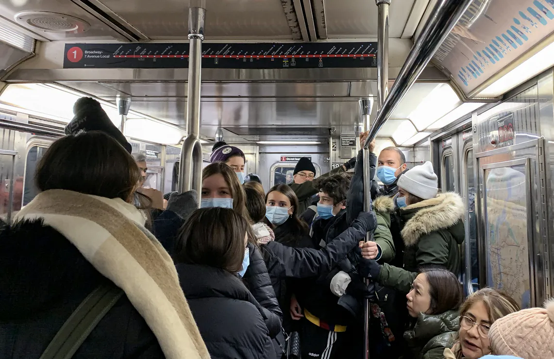 People wearing protective masks ride a train in New York on Feb. 29, 2020. (Chung I Ho/The Epoch Times)
