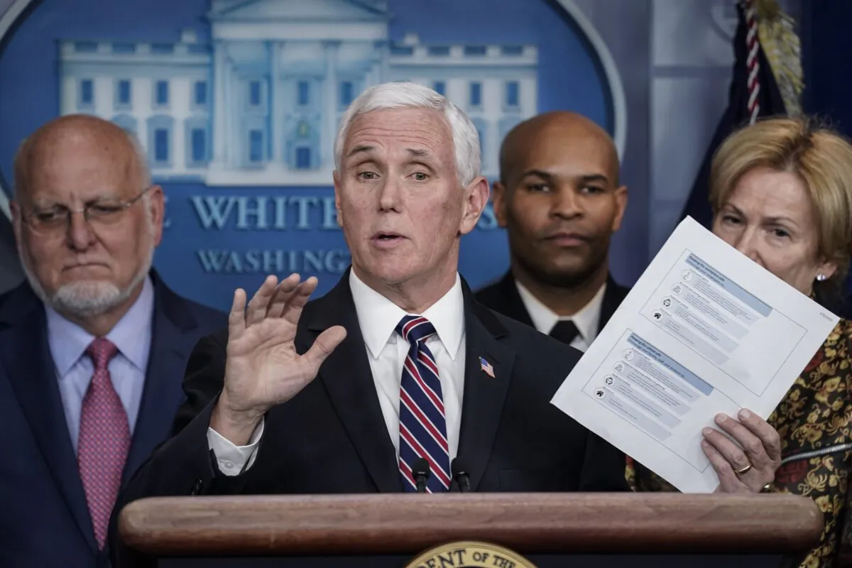 Vice President Mike Pence holds up a copy of community health guidelines during a press briefing with members of the White House Coronavirus Task Force at the White House in Washington on March 9, 2020. (Drew Angerer/Getty Images)