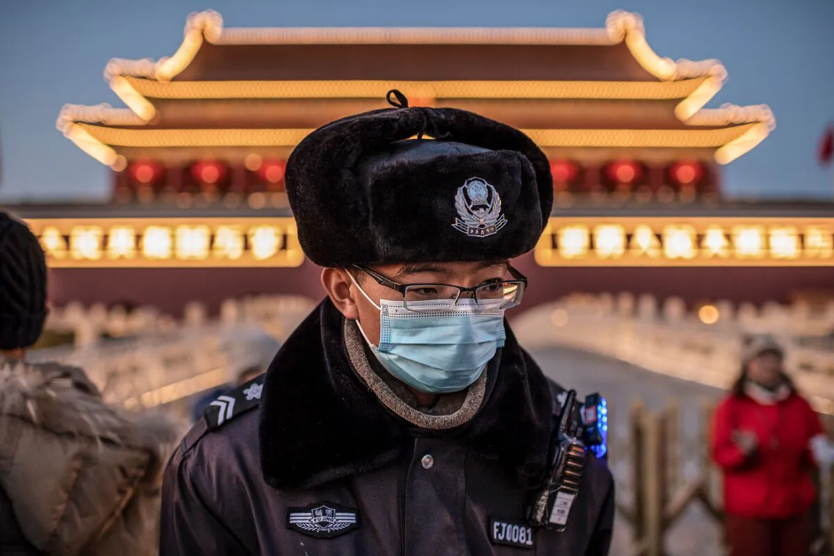 A police officer wearing a protective mask at Tiananmen Gate in Beijing on Jan. 23, 2020. (NICOLAS ASFOURI/AFP via Getty Images)