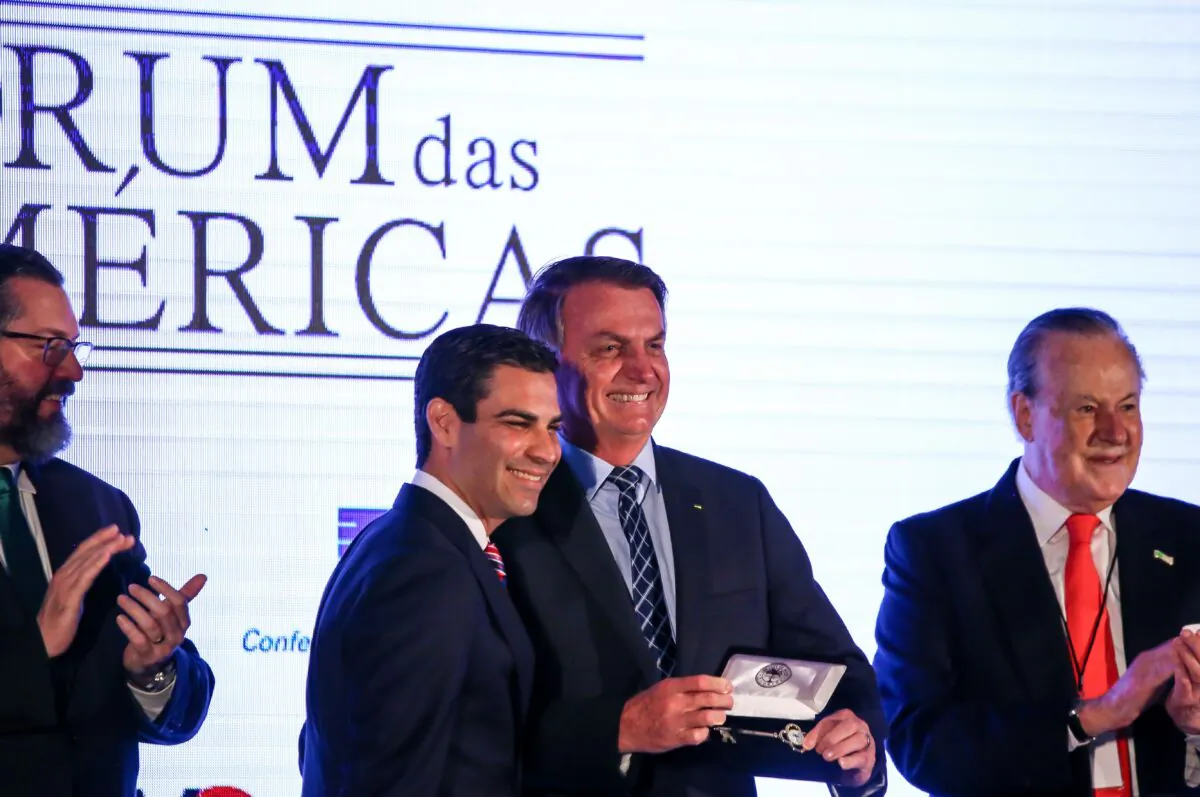 Miami Mayor Francis Suarez, second left, gives Brazilian President Jair Bolsonaro the keys to the city during the Forum Of The Americas at the InterContinental Miami in Miami, Florida, on March 10, 2020. (Zak Bennett/AFP via Getty Images)