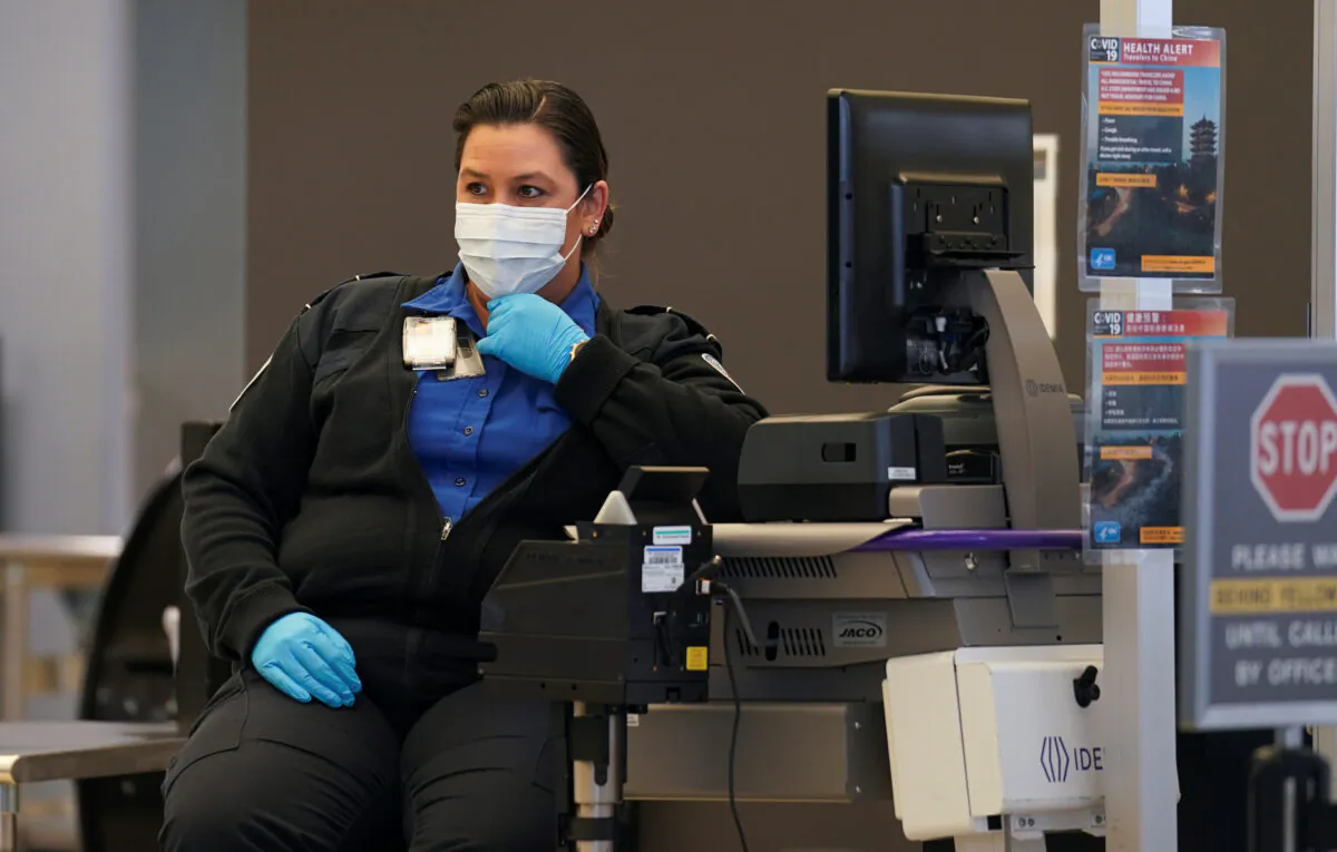 A TSA officer wearing a mask awaits passengers at Dulles International Airport, a day after U.S. President Donald Trump announced travel restrictions on flights from Europe to the United States for 30 days to try to contain the spread of the coronavirus, in Dulles, Virginia on March 12, 2020. (Kevin Lamarque/Reuters)