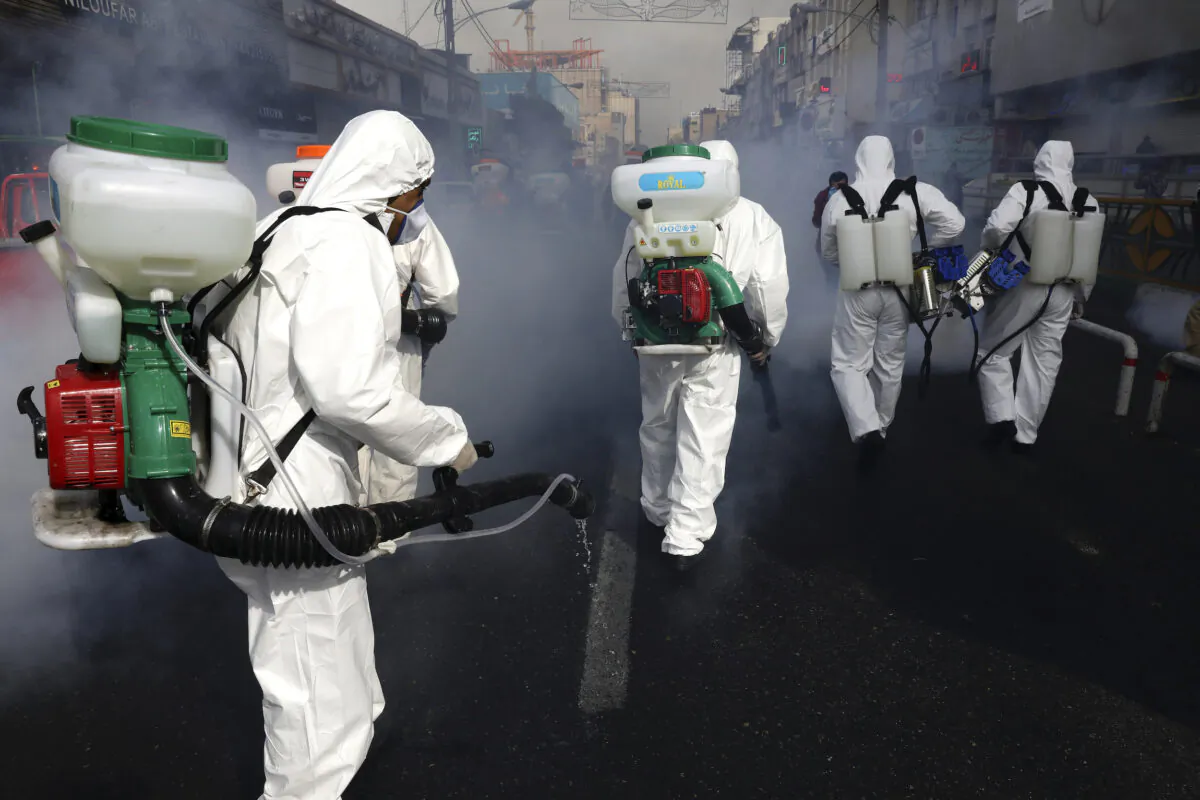 Firefighters disinfect a street against the new coronavirus, in western Tehran, Iran, on March 13, 2020. (Vahid Salemi/AP Photo)