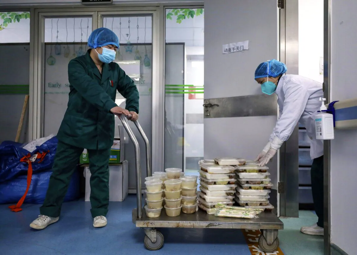 Workers deliver meals to Jinyintan Hospital, designated for critical COVID-19 patients, in Wuhan, China, on Feb. 13, 2020. (Chinatopix Via AP)