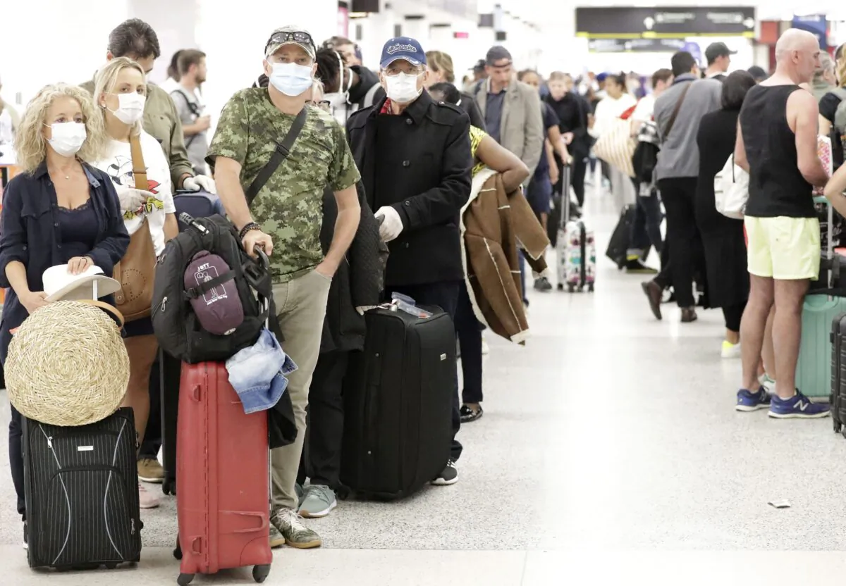 Travelers wait in line at the Miami International Airport in Miami, Florida, on March 13, 2020. (AP Photo/Wilfredo Lee)