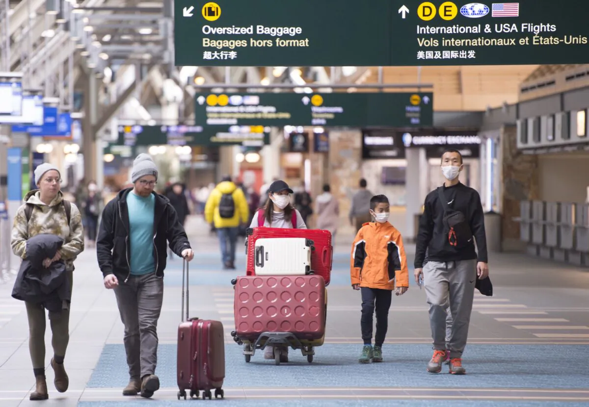 Travellers are seen at Vancouver International Airport in Richmond, B.C., on March 13, 2020.  (The Canadian Press/Jonathan Hayward)