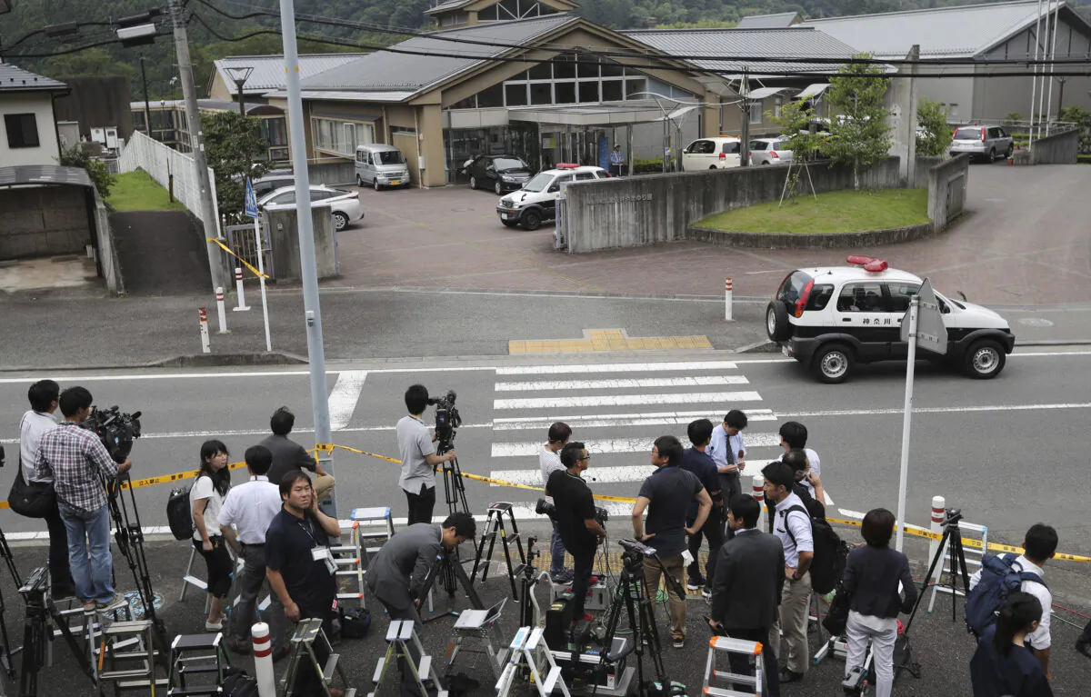 Journalists gather in front of Tsukui Yamayuri-en, a facility for the handicapped where a former care home employee killed 19 disabled people, in Sagamihara, outside Tokyo, Japan, on July 26, 2016. (Eugene Hoshiko/File/AP Photo)