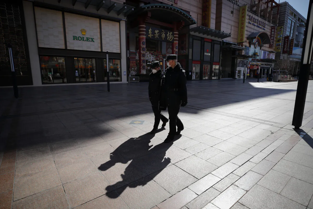 Security guards patrol the quiet Wangfujing shopping, a usually popular tourist spot before the new coronavirus outbreak in Beijing, on March 10, 2020. China's consumer spending and other business activity fell even more than expected in January and February due to its virus outbreak, adding to the ruling Communist Party's challenges as it tries to revive the world's second-largest economy. (Andy Wong/AP)