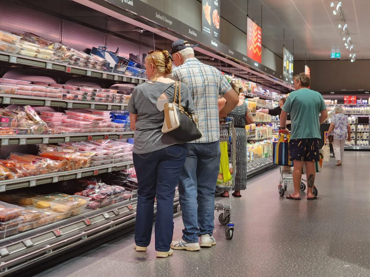 People shop in a supermarket aisle in a file photo. (Susan Mortimer/The Epoch Times)