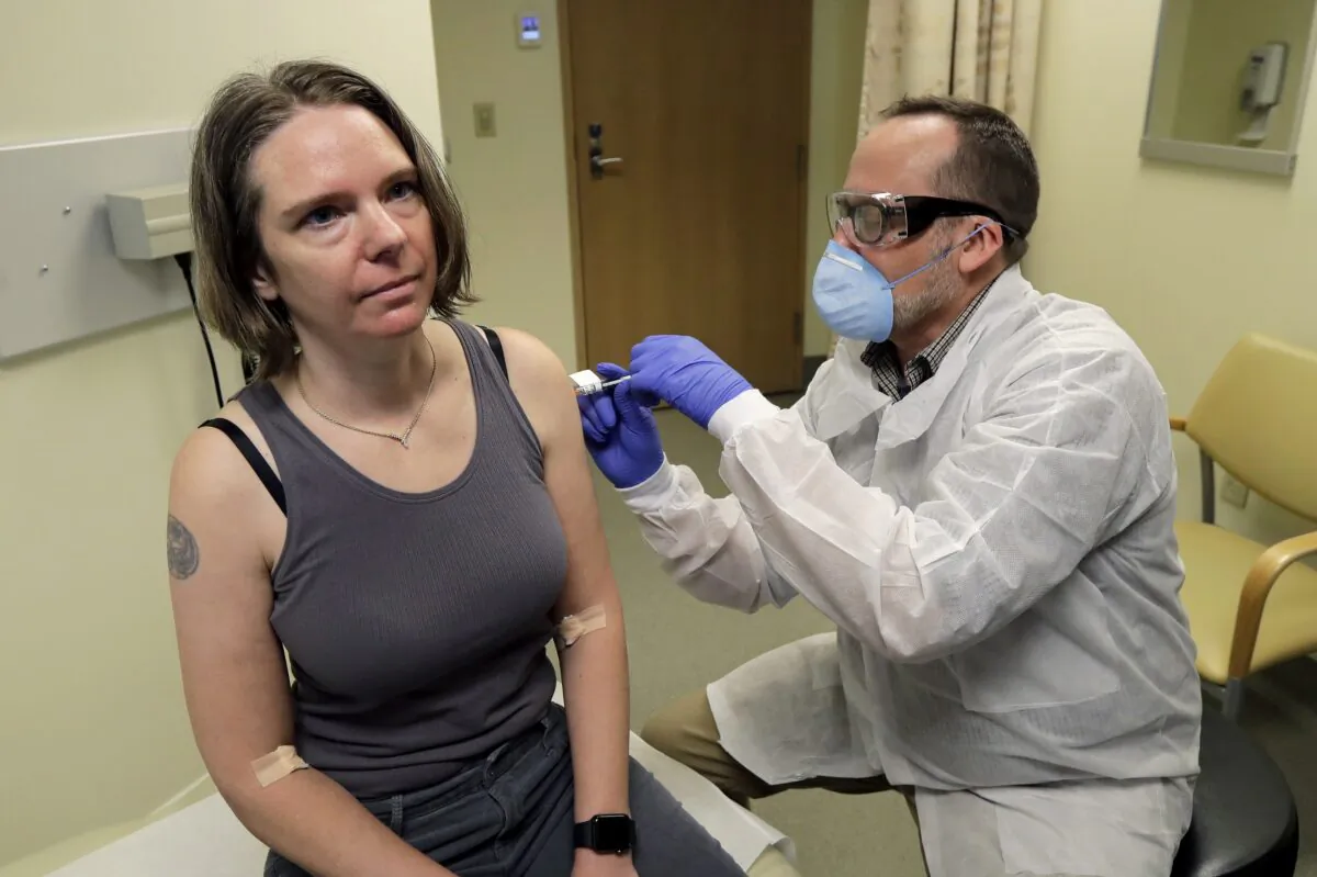 A pharmacist gives Jennifer Haller the first shot in the first-stage safety study clinical trial of a potential vaccine for the CCP virus, at the Kaiser Permanente Washington Health Research Institute in Seattle on March 16, 2020. The vaccine was developed by Moderna. (Ted S. Warren/AP Photo)