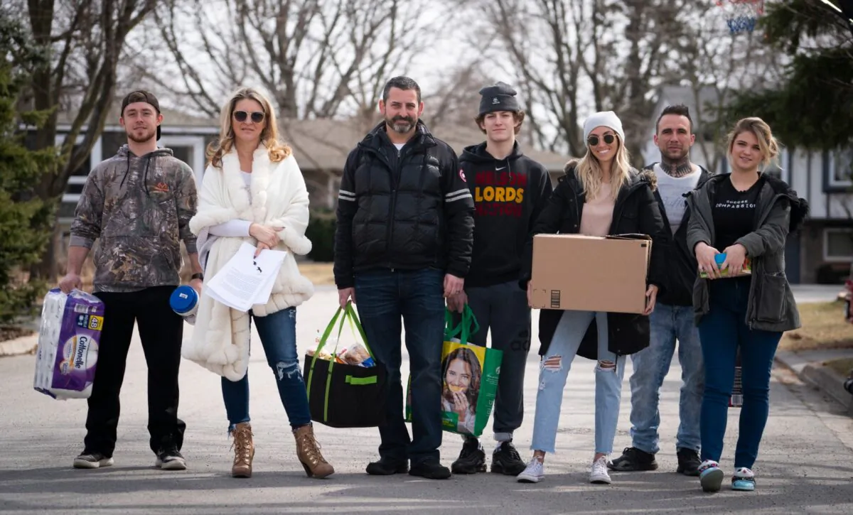 Jordan Banman, left to right, Jennifer Teufel-Shatilla, Mason Shatilla, Dave Shatilla, Zack St. Pierre, Sarah Moreby and Tori Teufel pose for a photo in their Burlington, Ont. neighbourhood on March 16, 2020. (Peter Power/The Canadian Press)