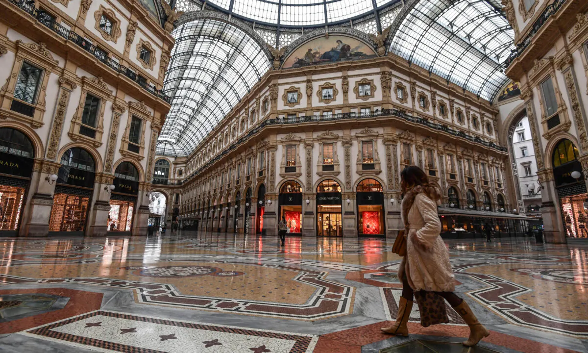 A woman walk cross the deserted Vittorio Emanuele II galleria shopping mall in Milan, Italy, on March 10, 2020. (Miguel Medina/AFP via Getty Images)