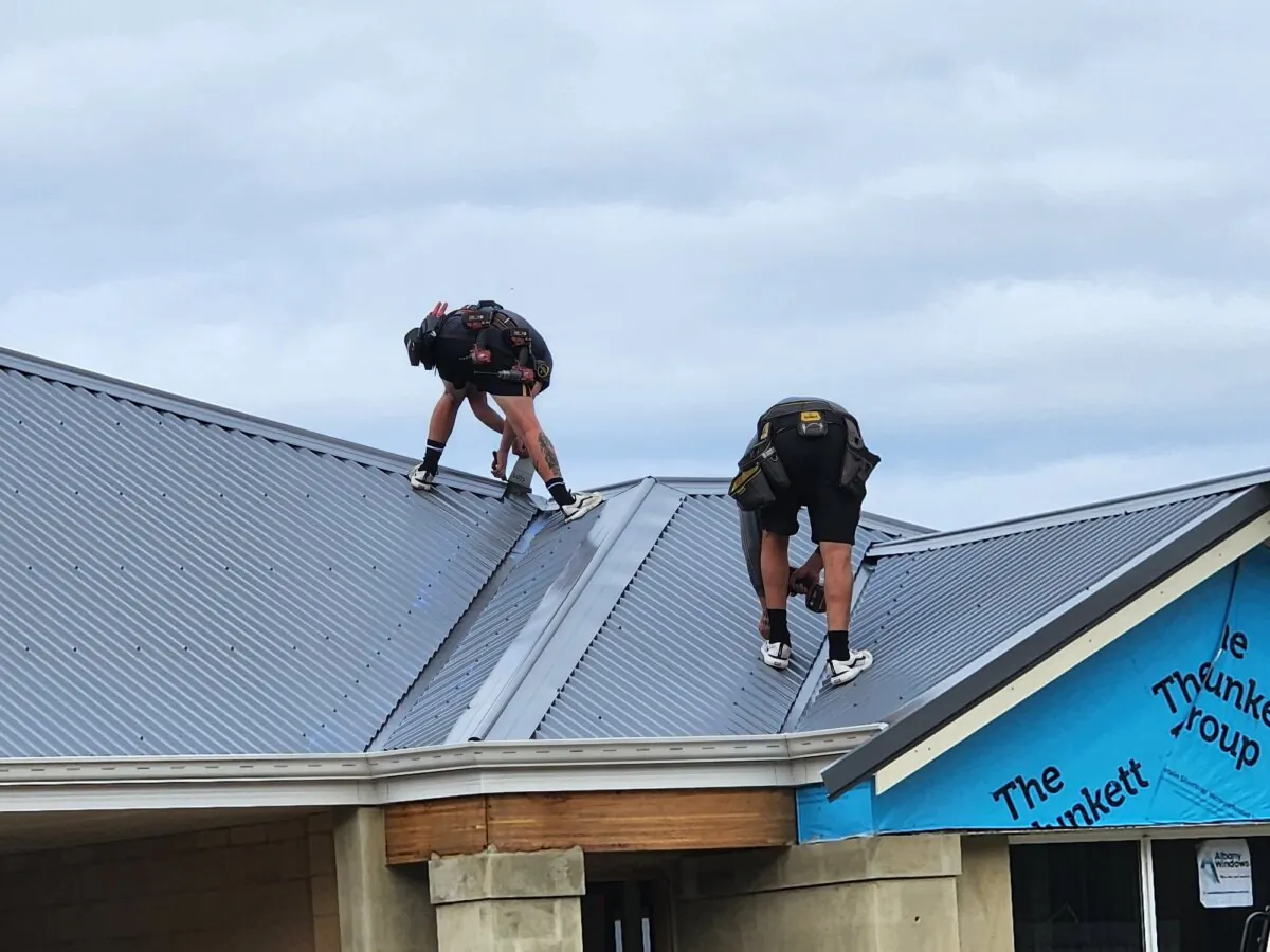 Two roofers install a roof on a new home in Albany, Western Australia, on Aug. 16, 2024. (Susan Mortimer/The Epoch Times)