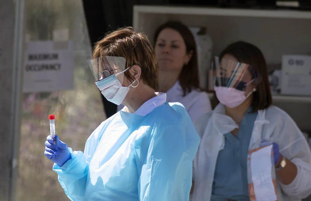 Medical workers at Kaiser Permanente French Campus test a patient for the novel coronavirus, COVID-19, at a drive-thru testing facility in San Francisco, Calif. on March 12, 2020. (Josh Edelson/AFP via Getty Images)