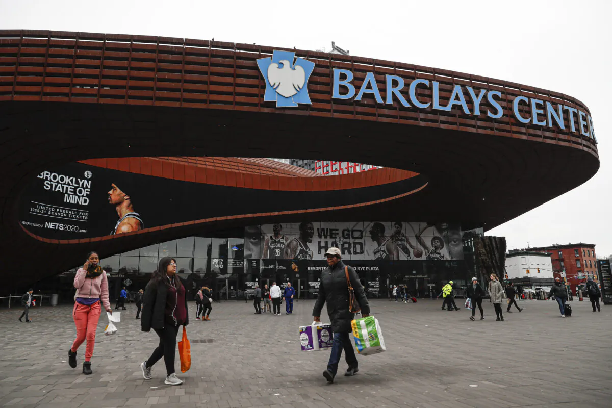 Pedestrians walk past the Barclays Center, which is home to the Brooklyn Nets, in the Brooklyn borough of New York City on March 12, 2020. (John Minchillo/AP Photo)
