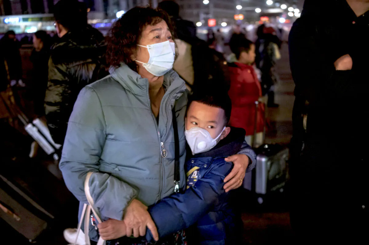 A Chinese boy hugs a relative as she leaves to board a train at Beijing Railway station in Beijing, China, on Jan. 21, 2020. (Kevin Frayer/Getty Images)