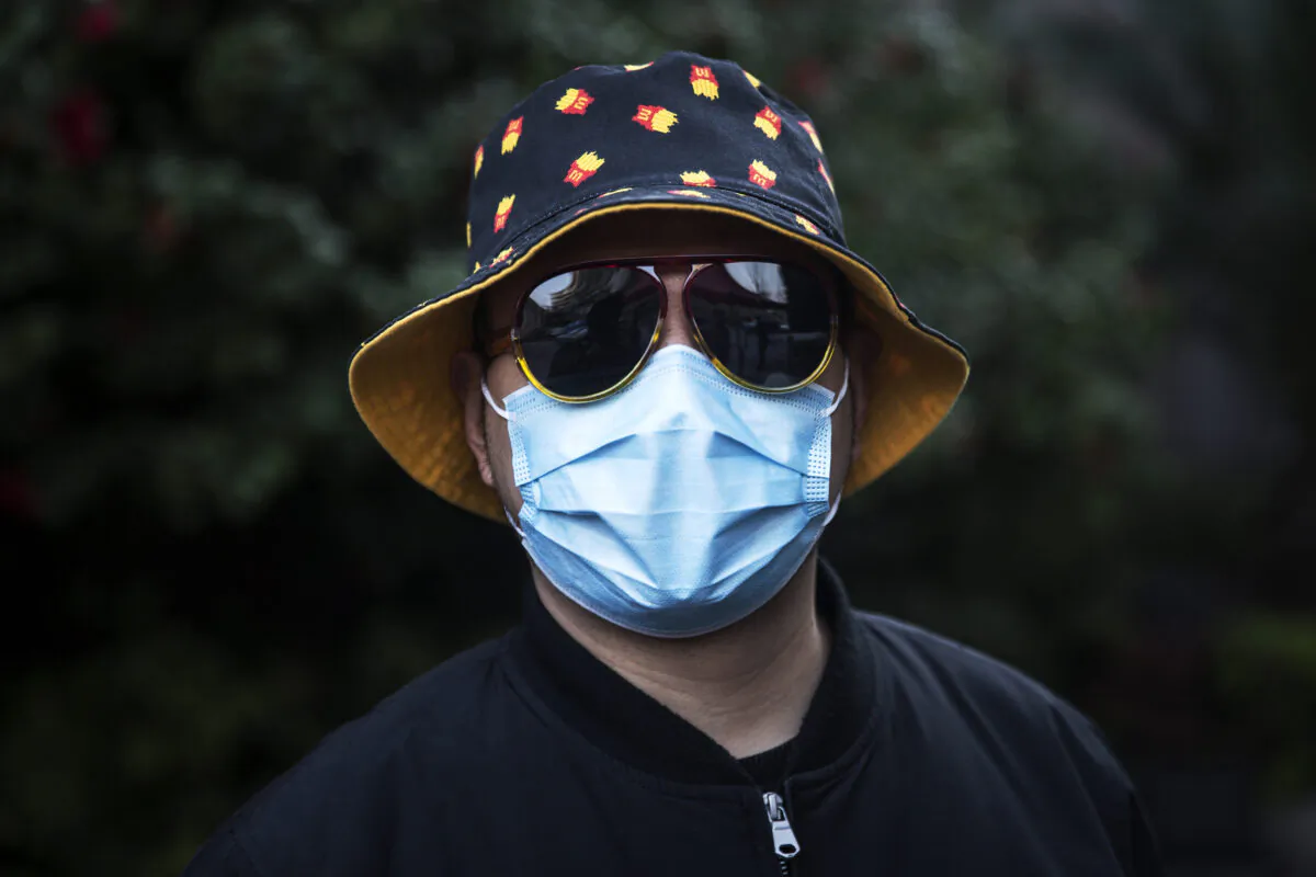 A man wears a mask at a makeshift barricade wall intended for deliveries that is meant to control entry and exit of outsiders to a residential compound in Wuhan, China, on March 14, 2020. (Stringer/Getty Images)