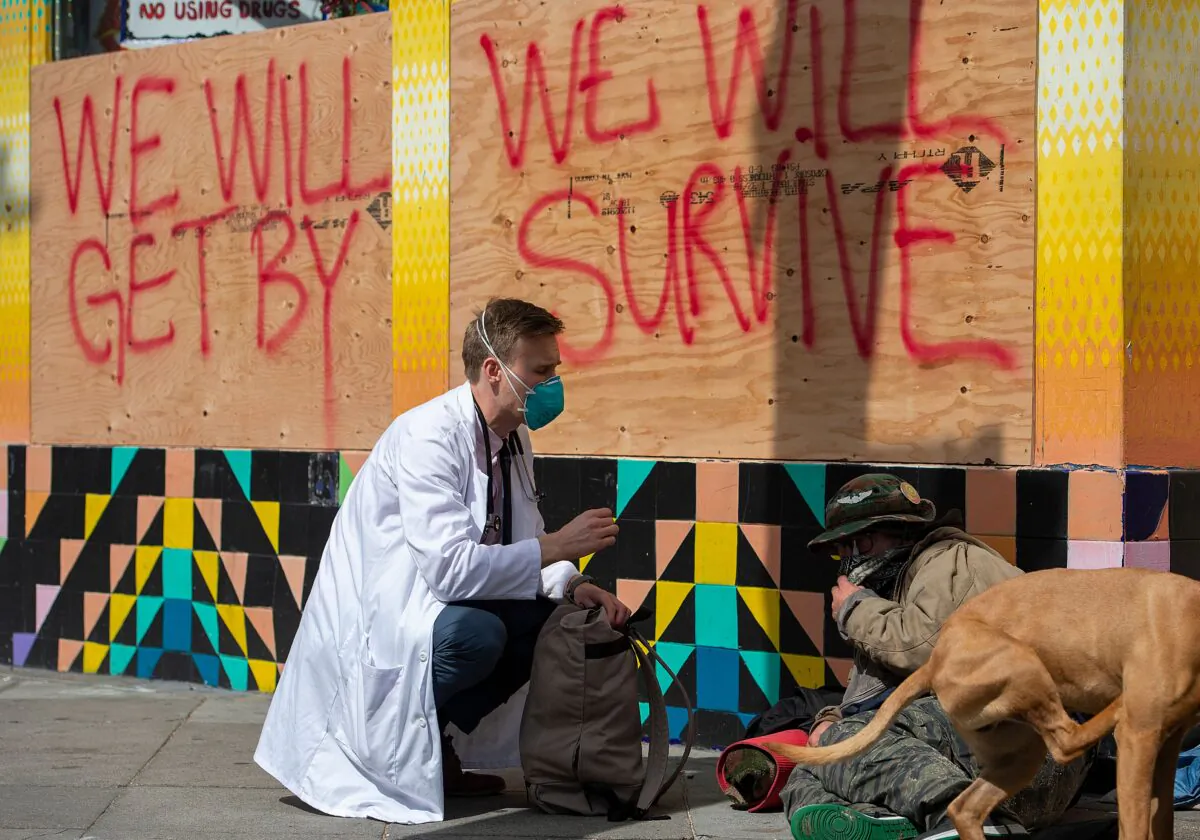 Stuart Malcolm, a doctor with the Haight Ashbury Free Clinic, speaks with homeless people about the CCP coronavirus in the Haight Ashbury area of San Francisco California on March 17, 2020. (Josh Edelso/AFP via Getty Images)