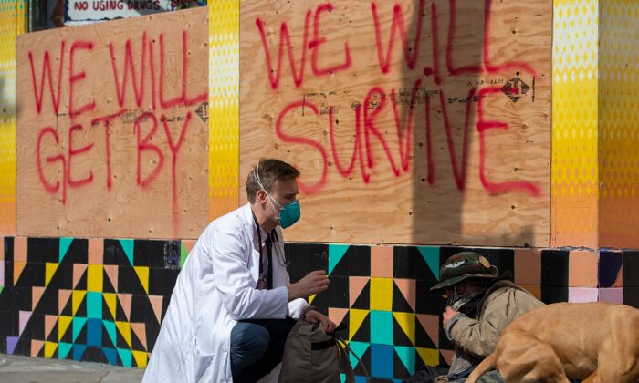 Stuart Malcolm, a doctor with the Haight Ashbury Free Clinic, speaks with homeless people about the CCP coronavirus in the Haight Ashbury area of San Francisco California on March 17, 2020. (Josh Edelso/AFP via Getty Images)