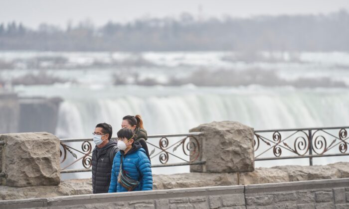 Tourists walk past the Horseshoe Falls in Niagara Falls, Ontario, Canada, on March 18, 2020. (Geoff Robins/AFP via Getty Images)